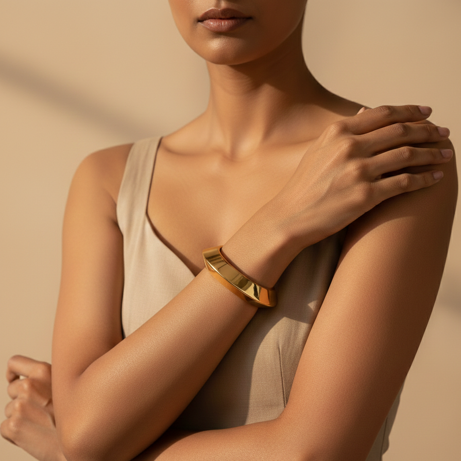 Woman wearing a gold bracelet on a beige background